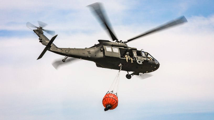 An Oklahoma Army National Guard UH-60 Black Hawk flies over the 702 Fire in Blaine County, Oklahoma after dropping more than 600 gallons of water on the fire, July 16, 2022. The Oklahoma National Guard is supporting the Oklahoma Forestry Services and local fire departments from the air using a UH-60 Black Hawk and a LUH-72 Lakota. (Oklahoma National Guard photo by Sgt. Anthony Jones)