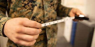 A U.S. Marine with Training and Education Command poses with a retractable measuring tape used for body composition assessment at Marine Corps Base Quantico, Virginia, Feb. 6, 2026. The Marine Corps is replacing the current semiannual height and weight screening with a waist-to-height ratio (WHtR) methodology as the initial step in its body composition evaluation process, in accordance with recent guidance from the Secretary of War. (U.S. Marine Corps photo by SSgt. Claudia Nix)