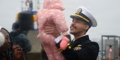 Lt. Berl McLaurin, assigned to the Virginia-class nuclear-powered fast-attack submarine USS South Dakota (SSN 790), meets his daughter for the first time as South Dakota returns to Naval Submarine Base New London in Groton, Conn., Feb. 20, 2026, following a six-month deployment to the U.S. European Command area of responsibility. South Dakota and crew operate under Submarine Squadron (SUBRON) 4, whose primary mission is to provide attack submarines that are ready, prepared, and committed to meet the unique challenges of undersea combat and deployed operations in unforgiving environments across the globe. (U.S. Navy photo by Chief Mass Communication Specialist Darren M. Moore)