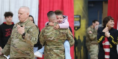 A soldier assigned to the Connecticut National Guard's 143rd Regional Support Group hugs his child following a sendoff ceremony for the unit at the Gov. William A. O'Neill Armory in Hartford, Conn. Feb. 21, 2026. The 143rd is scheduled to deploy to the Middle East in support of Operation Inherent Resolve. (U.S. Army photo by Spc. Juan Perez)