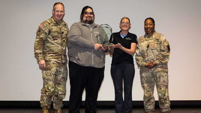 Fort Lee Better Opportunities for Single Soldiers program leaders Sherman Cordle (center left), BOSS advisor and Recreation Specialist Facility Manager; and BOSS President Sgt. 1st Class Jamie Ramsdell (center right); celebrate their FY25 BOSS Awards competition first place in Best Community Service for a medium-sized installation with Fort Lee Garrison Commander Col. Rich Bendelewski (far left) and Fort Lee Garrison Command Sergeant Major Command Sgt. Maj. Nickea Harris at a Garrison Town Hall event Feb. 26 at the Beaty Theater, Fort Lee, Va.
