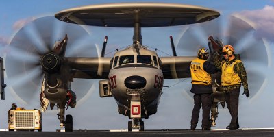 U.S. Navy Sailors signal to an E-2D Hawkeye aircraft, attached to Airborne Command and Control Squadron 124, as it taxis on the flight deck of world's largest aircraft carrier, USS Gerald R. Ford (CVN 78), in support of Operation Epic Fury, Feb. 28, 2026. (U.S. Navy photo)