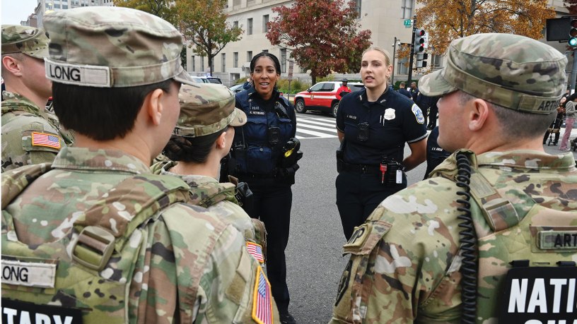 U.S. Army Soldiers assigned to Joint Task Force - District of Columbia conduct a presence patrol alongside members of the Metropolitan Police Department (MPD) during the National Veterans Parade in Washington, D.C., Nov. 9, 2025. The official theme for Veterans Day 2025 is "Service to Our Nation," which honors the contributions of all who have served in the U.S. Armed Forces. (U.S. Air National Guard photo by Master Sgt. Arthur M. Wright)
