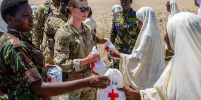 U.S. Air Force Capt. Bailey Ziman, center, an airman assigned to 475th Expeditionary Air Base Squadron, and members of the Kenya Defence Forces disperse comfort kits from the American Red Cross to locals at Mokowe Arid School in Mokowe, Kenya, Feb. 12, 2026. The kits include toothbrushes, toothpaste and soap, among other items, to address a shortage of critical resources in vulnerable communities within the area of operations for Forward Operating Site Manda Bay Kenya. (Photo courtesy of Staff Sgt. Alec Golden)