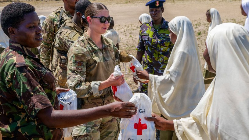 U.S. Air Force Capt. Bailey Ziman, center, an airman assigned to 475th Expeditionary Air Base Squadron, and members of the Kenya Defence Forces disperse comfort kits from the American Red Cross to locals at Mokowe Arid School in Mokowe, Kenya, Feb. 12, 2026. The kits include toothbrushes, toothpaste and soap, among other items, to address a shortage of critical resources in vulnerable communities within the area of operations for Forward Operating Site Manda Bay Kenya. (Photo courtesy of Staff Sgt. Alec Golden)