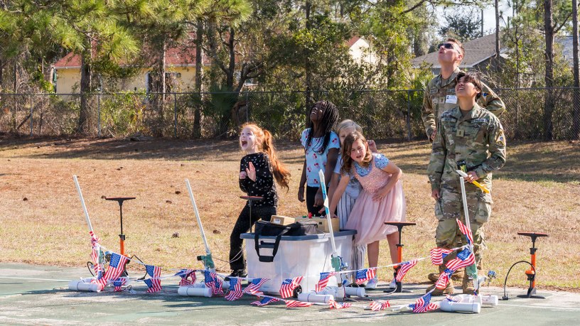 U.S. Space Force 2nd Lt. Dominic Anastasio and 2nd Lt. Athena Gesite, 1st Range Operations Squadron range operations commanders in training, observe as students launch paper rockets in Brevard County, Florida, Feb. 19, 2026. Through hands-on activities like rocket design and launch demonstrations, Guardians helped students explore basic engineering principles while strengthening connections between the Space Force and the local community that supports the Eastern Range mission. (U.S. Space Force photo by Gwen Kurzen)