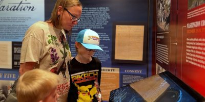 Tracy Warren and her children interact with a high-definition touch screen inside the Freedom 250 mobile museum at Fort Campbell, Ky., Feb. 25, 2026. The Warren family, who recently studied the American Revolution as part of their homeschool curriculum, used the exhibit's interactive technology to further explore 250 years of United States history.