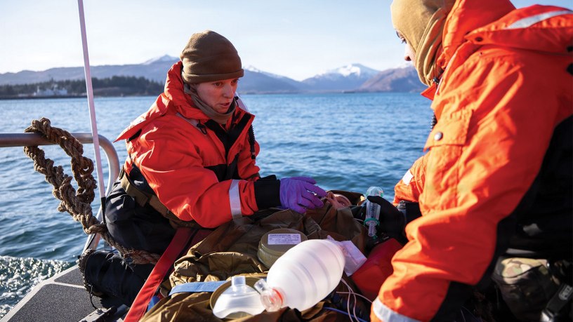 U.S. Navy Lt. Hannah Cunningham, left, assigned to En-route Care System (ERCS) Team 52, and U.S. Navy Hospital Corpsman 1st Class Daniel Rodriguez, right, assigned to ERCS Team 52, treat a patient aboard a small boat during a ship-to-shore medical evacuation exercise as part of ARCTIC EDGE 2026 (AE26) in Kodiak, Alaska, Feb. 26, 2026. AE26 is a NORAD and U.S. Northern Command-led homeland defense exercise designed to improve readiness, demonstrate capabilities, and enhance Joint and Allied Force interoperability in the Arctic. (U.S. Navy photo by Mass Communication Specialist 1st Class Abigayle Lutz)