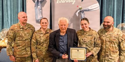 Left to right, Senior Airman Jason Anderson, 67th Aerial Port Squadron air transportation journeyman, Master Sgt. Jennifer Ramaekers, 151st Utah Air Nation Guard munitions, William Reid Rowland, Captain Leila Rahebi Air Force contracting officer, and Tech. Sgt. Dom Gioffre, 67th Aerial Port Squadron air transportation craftsman, pose for a picture for Rowland’s 100th birthday on Feb. 28, 2026. (Courtesy Photo)