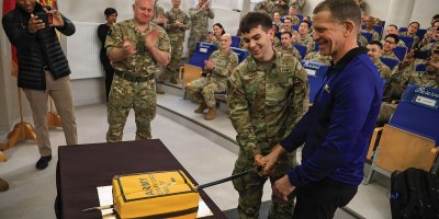 Army Emergency Relief CEO, retired Sergeant Major of the Army Tony Grinston, cuts the cake to celebrate the opening of the AER branch at the U.S. Army Garrison Poland on March 3, 2026, in Poznan, Poland. The opening of the branch includes a pilot program for U.S. Army Reserve Soldiers to receive access to loan and grants. (U.S. Army Reserve photo by Staff Sgt. Stanford Toran)