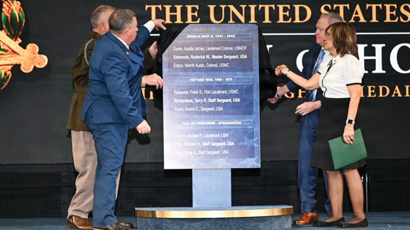 Army Command Sgt. Maj. Terry P. Richardson, left, Chris Edmonds, and Robert and Linda Ollis unveil a plaque bearing the names of the three newest Medal of Honor recipients during a Hall of Heroes induction ceremony at Joint Base Myer-Henderson Hall in Arlington, Va., March 3, 2026.