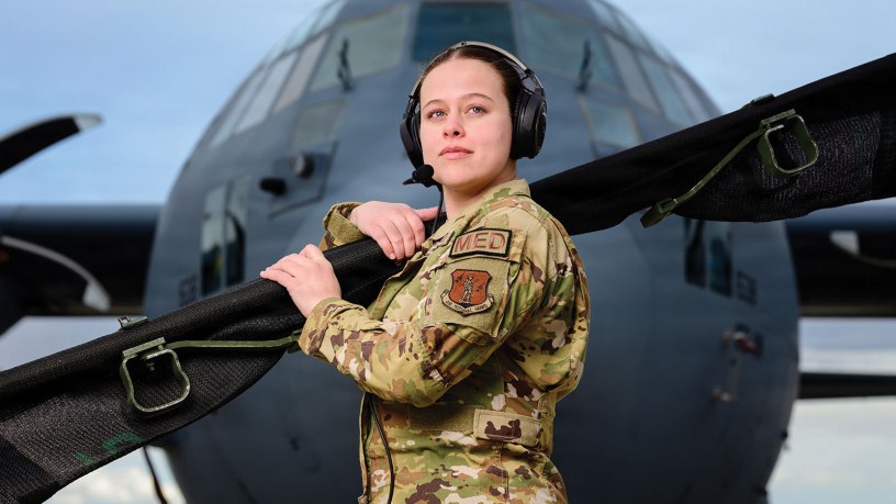 Senior Airman Kaylee Hess, an aeromedical evacuation technician with the 187th Aeromedical Evacuation Squadron, 153rd Airlift Wing, Wyoming Air National Guard, stands in front of a C-130 Hercules aircraft assigned to the 153rd Airlift Wing while holding a folded litter in Cheyenne, Wyo., March 5, 2026. Hess was named the 2025 Outstanding Aeromedical Evacuation Crew Member of the Year. (U.S. Air National Guard photo by Master Sgt. Jon Alderman)