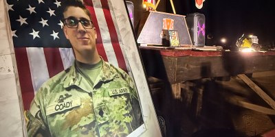 An enlarged image of Sgt. Declan J. Coady is illuminated during a special “Elite Hero Workout of the Day” hosted by Company E, 551st Signal Battalion, on March 9. Coady was one of six American Soldiers killed when an unmanned aircraft struck a tactical command center at the Port of Shuaiba in Kuwait on March 1.