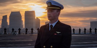 A U.S. Navy officer watches over Sailors manning the rails on the flight deck of Nimitz-class aircraft carrier USS Nimitz (CVN 68) during the ship's departure from Naval Air Station North Island, San Diego, March 14, 2026. Nimitz is underway in the U.S. 3rd Fleet area of operations as part of a scheduled homeport shift to Norfolk, Virginia. (U.S. Navy photo by Mass Communication Specialist 3rd Class Gina Gallia)