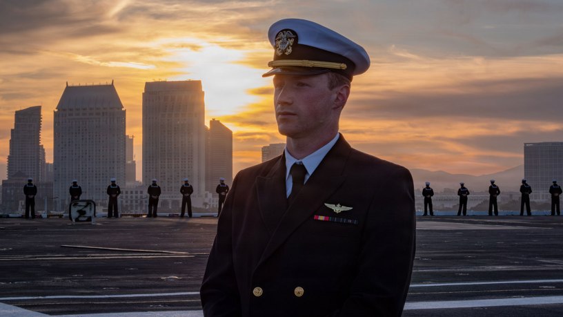 A U.S. Navy officer watches over Sailors manning the rails on the flight deck of Nimitz-class aircraft carrier USS Nimitz (CVN 68) during the ship's departure from Naval Air Station North Island, San Diego, March 14, 2026. Nimitz is underway in the U.S. 3rd Fleet area of operations as part of a scheduled homeport shift to Norfolk, Virginia. (U.S. Navy photo by Mass Communication Specialist 3rd Class Gina Gallia)