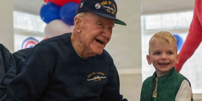 Freeman Johnson greets his great-grandson, Owen McGrath, during his 106th birthday party at the Barnstable Adult Community Center in Hyannis, Mass., March 18, 2026. Johnson, one of the oldest survivors of the attack on Pearl Harbor, Hawaii, was stationed aboard the USS St. Louis on the morning of the attack.