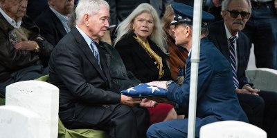 U.S. Air Force Chief of Staff Gen. Kenneth Wilsbach presents the U.S. flag to James Anderson following the funeral service for Anderson's father, U.S. Air Force Col. Clarence “Bud” Anderson, in Section 38 of Arlington National Cemetery, Arlington, Virginia, Monday, March 30, 2026.