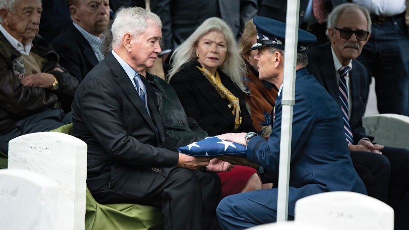 U.S. Air Force Chief of Staff Gen. Kenneth Wilsbach presents the U.S. flag to James Anderson following the funeral service for Anderson's father, U.S. Air Force Col. Clarence “Bud” Anderson, in Section 38 of Arlington National Cemetery, Arlington, Virginia, Monday, March 30, 2026.