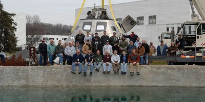 Engineers and technicians with the Naval Surface Warfare Center, Carderock Division, pose at the command’s test pond in West Bethesda, Maryland, March 25, 2009. The team supported the development and testing of NASA’s Orion capsule, conducting full-scale and model-scale evaluations of the capsule's performance during splashdown and recovery operations. Pictured are Mark Melendez, front row, second from left, and Lauren “Tink” Hanyok, front row, second from right. (U.S. Navy photo)