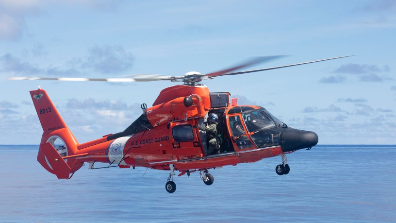 Petty Officer 2nd Class Lonnie Taber retrieves the winch on a U.S. Coast Guard MH-65E Dolphin helicopter following an in-flight refueling evolution with U.S. Coast Guard Cutter Munro (WMSL 755) in the Philippine Sea, Sept. 26. Munro is deployed to the Indo-Pacific to advance relationships with ally and partner nations to build a more stable, free, open and resilient region with unrestricted, lawful access to the maritime commons. (U.S. Navy photo by Chief Petty Officer Brett Cote)