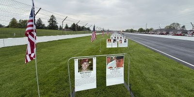 Placards of Indiana's fallen service members line the back straight at the Indianapolis Motor Speedway as part of the Gold Mile prior the 500 Festival Mini-Marathon in Indianapolis, Saturday, May 3, 2025. The Gold Mile honors Indiana's fallen service members since Sept 11, 2001. (Indiana National Guard photo by Master Sgt. Jeff Lowry)