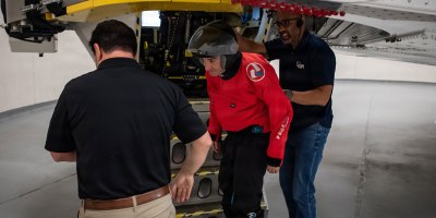 John Trentini, left, a NASA flight surgeon, and Andre Scott, right, an operations technician assigned to Wright-Patterson Air Force Base, Ohio, assist NASA astronaut Jack Hathaway as he exits the Air Force Research Laboratory's 711th Human Performance Wing's centrifuge, June 20, 2025. Hathaway was one of five astronauts from NASA, the Canadian Space Agency and the European Space Agency who completed centrifuge training, which simulates the gravitational forces experienced during launch and reentry.