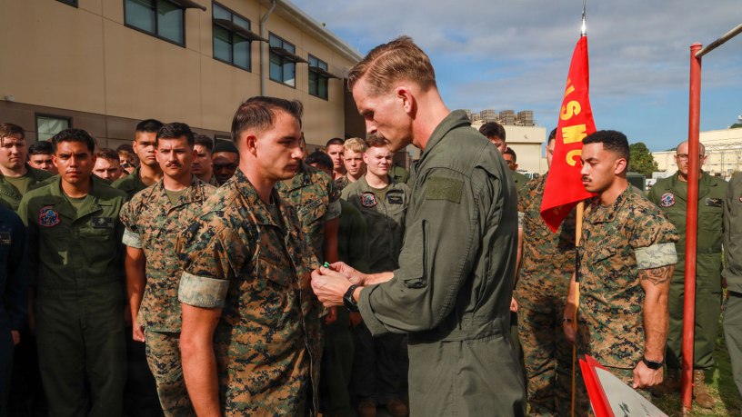 U.S. Marine Corps Lt. Col. Paul Cordes, commanding officer of Marine Aerial Refueler Transport Squadron (VMGR) 153, Marine Aircraft Group 24, 1st Marine Aircraft Wing, awards Sgt. Garrett Sloan, a loadmaster with VMGR-153, the Navy and Marine Corps Commendation Medal at Marine Corps Air Station Kaneohe Bay, Hawaii, March 5, 2026. Sloan received the award after rescuing two local children who were swept out to sea by a rip current while swimming at Makapu’u beach. (U.S. Marine Corps photo by Lance Cpl. Chandler Evans)