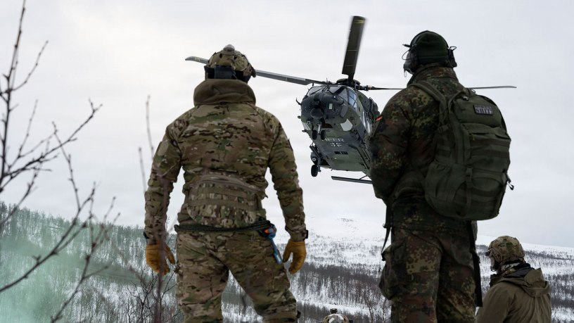 A U.S. Air Force Airman assigned to the 57th Rescue Squadron based out of Aviano Air Base, Italy, and a German army air corps pilot assigned to the 30 Transport Helicopter Regiment based out of Niederstetten Air Base, Germany, watch an NHIndustries NH90 arrive on scene at a combat search and rescue scenario during Exercise Cold Response 26 in Norway, March 19, 2026.