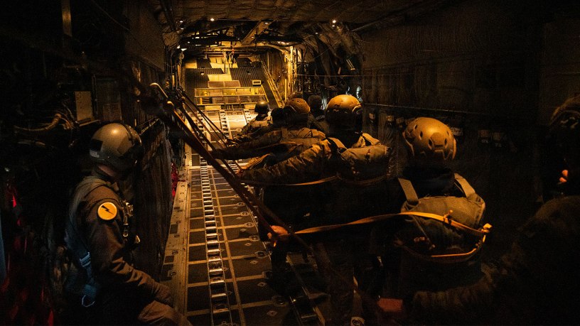 U.S. Air National Guard Tech. Sgt. Jacob Thomas, a loadmaster with the 103d Airlift Wing, assists paratroopers from the 160th Special Operations Aviation Regiment as they prepare to jump from a C-130 Hercules during Joint Airborne/Air Transportability Training at Base Lewis-McChord, Wash., March 25, 2026. The 103d and 160th executed multiple heavy equipment and personnel airdrops throughout the week, reinforcing precision delivery capabilities and joint mission execution. (Photo by U.S. Air National Guard Captain Jennifer Kaprielian)