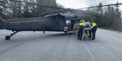 Tennessee Guardsmen and local Emergency Medical Services transfer a park visitor suffering cardiac arrest into a Tennessee Army National Guard UH-60 Blackhawk along Kuwohi Road in the Great Smoky Mountain National Park, April 1.