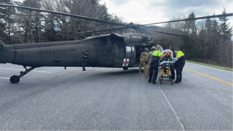 Tennessee Guardsmen and local Emergency Medical Services transfer a park visitor suffering cardiac arrest into a Tennessee Army National Guard UH-60 Blackhawk along Kuwohi Road in the Great Smoky Mountain National Park, April 1.