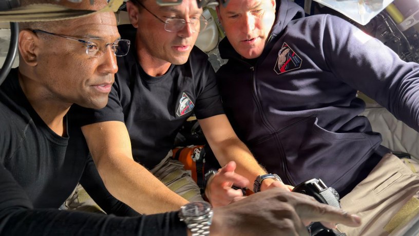 NPS alumni U.S. Navy Capt. Victor Glover, spacecraft pilot, and mission commander retired U.S. Navy Capt. Reid Wiseman, along with mission specialist Jeremy Hansen of the Canadian Space Agency prepare for their journey around the far side of the Moon by configuring their camera equipment shortly before beginning their lunar flyby observations. (Credit NASA)