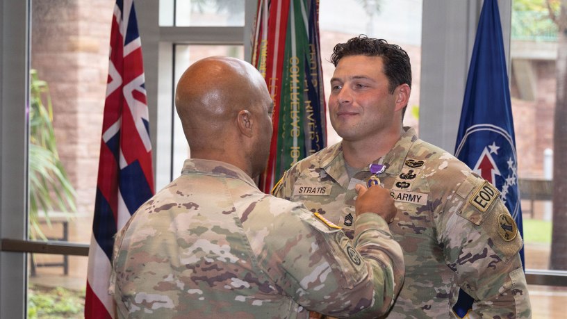 U.S. Army Sergeant First Class Ryan Stratis, U.S. Army Pacific, Explosive Ordinance Disposal (EOD) Plans and analysis NCO, Is pinned on the Purple Heart medal by General Ronald P. Clark, USARPAC, Commanding General, at Fort Shafter, Hawaii, Apr. 10, 2026. Stratis was awarded the purple heart for valor during his deployment to Afghanistan in 2019. (U.S. Army photo by PV2 Parker Phillips)