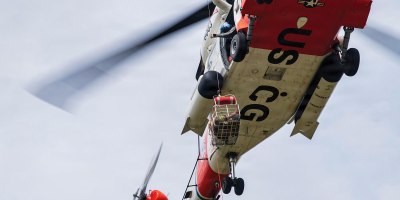 A U.S. Coast Guard Sikorsky MH-60 Jayhawk helicopter from Coast Guard Station Astoria, Oregon, conducts takeoff and hoist iteration in a hover as ground crew members, made up of Flight Medics, Search and Rescue Corpsmen, and Rescue Swimmers, train with simulated patients at the Sandy River Airport, Sandy, Oregon, on April 10, 2026.