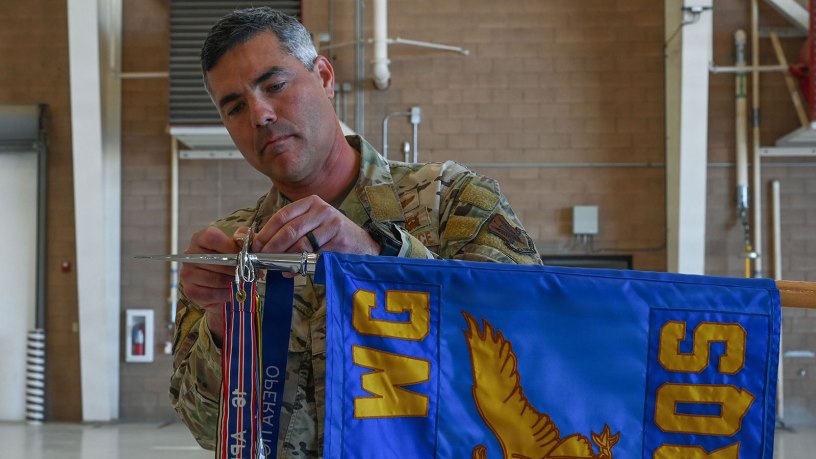 U.S. Air Force Col. Jose Cabrera, 355th Wing commander, places a new Operation Allies Refuge streamer on the 55th Rescue Squadron guidon during a Presidential Unit Citation ceremony at Davis-Monthan Air Force Base, Arizona, April 17, 2026. The campaign streamer denotes the unit’s service and battle honors earned during unconventional combat search and rescue operations in support of the final withdrawal of U.S. troops from Afghanistan, resulting in the safe evacuation of 124,000 people between July 16 and Aug. 31, 2021. (U.S. Air Force photo by Staff Sgt. Kahdija Slaughter)
