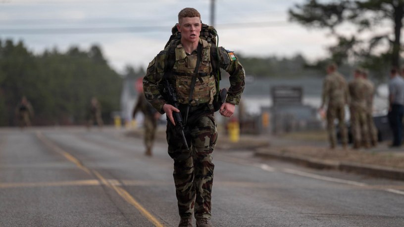 An Irish Defence Forces soldier crosses the finish line of the 12-mile ruck during the 2026 Massachusetts National Guard Best Warrior Competition at Camp Edwards, Massachusetts, April 17, 2026. The three-day competition brought together more than 40 soldiers, noncommissioned officers and airmen from the Massachusetts National Guard and Irish Defence Forces, testing them physically and mentally while enhancing skills, building relationships and expanding professional knowledge. (Air National Guard photo by Senior Airman Julia Ahaesy)