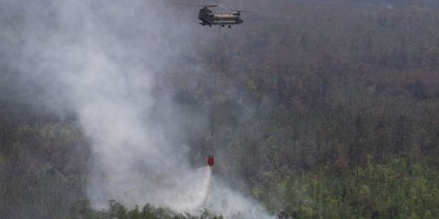 A CH-47 Chinook helicopter crew with Bravo Company, 1st General Support Aviation Battalion, 169th Aviation Regiment, 78th Aviation Troop Command, Georgia Army National Guard, dumps water with a Bambi Bucket during the wildfire suppression efforts in Pineland, Georgia, April 25, 2026. Defense plays an integral role in declared emergencies by providing a versatile and ready force capable of responding to natural and manmade disasters across the United States. (U.S. Army National Guard photo by Sgt. Jordan McNeal)