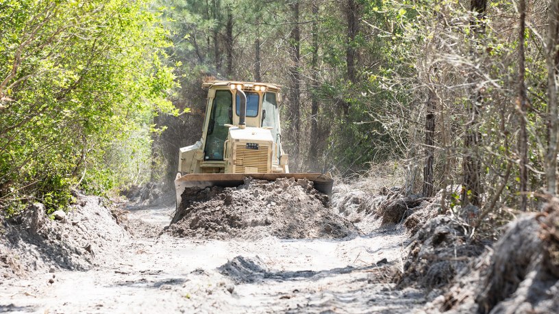 A bulldozer crew with 877th Engineer Company, 878th Engineering Battalion, 648th Maneuver Enhancement Brigade, Georgia National Guard, clears burnt brush during wildland fire suppression efforts in Pineland Georgia, April 29, 2026. The Georgia Department of Defense plays an integral role in declared emergencies by providing a versatile and ready force capable of responding to natural and manmade disasters across the United States.