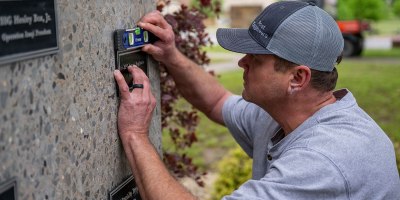 Arkansas Dept. of the Military employee Kevin Shaffer installs a plaque April 29, 2026, that honors Pfc. James Reginato who was injured by enemy fire in Mignano, Italy, on Dec. 15, 1943. He succumbed to his injuries two days later on Dec. 17, 1943. Col. Matt Anderson spent two years conducting research on his own time, finding six Soldiers to add to the memorial.