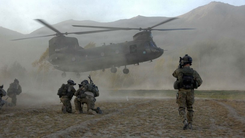 Soldiers of the joint force brace themselves against the CH-47 Chinook helicopter rotor wash at a helicopter landing zone in Zanakhan District, of Ghazni province, Afghanistan, on Oct. 31, 2009. (DoD photo by Spc. Walter Reeves, U.S. Army. (Released))