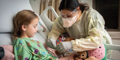 Sheri Flores, Pediatric Intensive Care Unit charge nurse, secures a pulse oximeter on patient, Margaret Moore, at Brooke Army Medical Center, Fort Sam Houston, Texas, March 8, 2022. Moore is the first patient admitted to BAMC’s new Pediatric Intensive Care Unit. (U.S. Army photo by Jason W. Edwards)