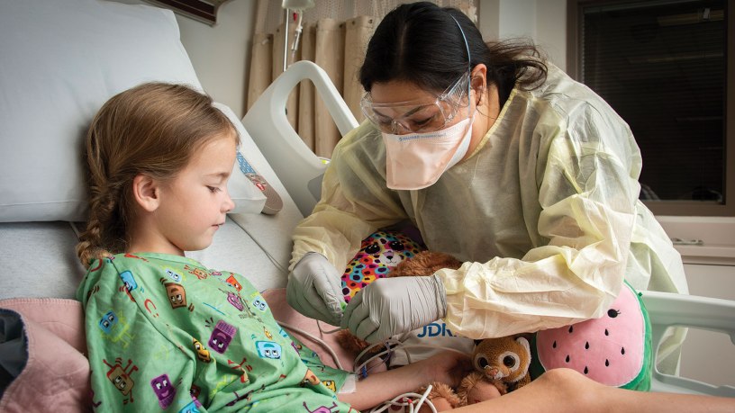Sheri Flores, Pediatric Intensive Care Unit charge nurse, secures a pulse oximeter on patient, Margaret Moore, at Brooke Army Medical Center, Fort Sam Houston, Texas, March 8, 2022. Moore is the first patient admitted to BAMC’s new Pediatric Intensive Care Unit. (U.S. Army photo by Jason W. Edwards)