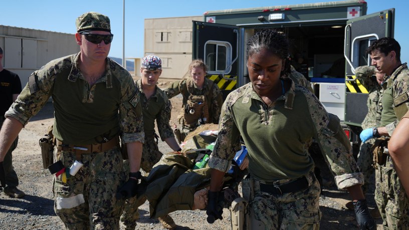 Hospital Corpsman 2nd Class Nya Jobs (right), respiratory therapist, Lt. j.g. Mark Gregg (left), trauma nurse, Capt. David Samaha (middle), general surgeon, and Lt. j.g. Melissa Sullivant (back), trauma nurse, all assigned to Navy Medicine Readiness and Training Command (NMRTC) Jacksonville, transport a casualty from an ambulance into their mission support site during an Expeditionary Resuscitative Surgical System (ERSS) course conducted by Naval Expeditionary Medicine Warfighter Development Center (NEMWDC) Oct. 21, 2025.