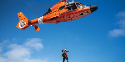 U.S. Coast Guard Petty Officer 2nd Class Kimble Petersen, an aviation survival technician assigned to Coast Guard Air Station Barbers Point in Kapolei, Hawaii, is lowered from a Coast Guard MH-65 Dolphin helicopter during a training exercise in Kaneohe Bay, Hawaii Nov. 12, 2025. Coast Guard rescue swimmers train to operate in high seas, heavy surf, and extreme weather conditions, ensuring they can respond during hurricanes, storms, and ship disasters. (U.S. Coast Guard photo by Petty Officer 2nd Class Tyler Robertson)