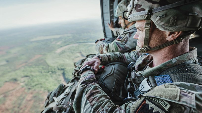 Staff Sgt. Taylor Siebrandt and Sgt. 1st Class James Miller, with Team 6 representing the Army National Guard Warrior Training Brigade, sit in the open door of a UH-60 Black Hawk helicopter in flight to prepare for their spot jump onto Fryar Drop Zone during the 2026 Best Jumpmaster Competition at Fort Benning, Georgia, April 8, 2026. The competition tested the proficiency and precision of jumpmaster teams through a series of tactical airborne operations. (U.S. Army photo by Capt. Stephanie Snyder)