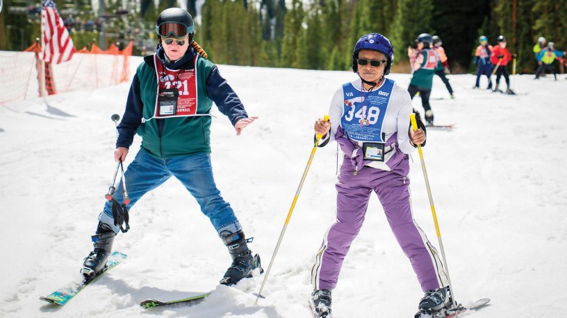 U.S. Army Veteran Suzette Pinnock skis alongside a volunteer instructor during the 40th National Disabled Veterans Winter Sports Clinic in Snowmass, Colorado, April 10, 2026. Of the 319 Veterans attending this year’s clinic, just 69 are women and only 58 served during the Gulf War era, underscoring Pinnock’s message that more Veterans should take that first effort to get out and get connected. (U.S. Department of Veterans Affairs photo by Emily Bell)
