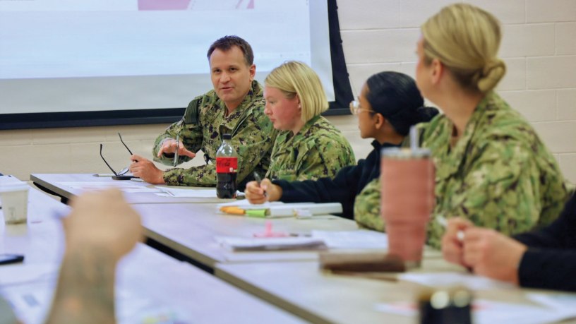 Capt. Mark Miller (back left), chief nursing officer assigned to Navy Medicine Readiness and Training Command Twentynine Palms, discusses the impact a hypothetical pandemic would have on the command with hospital leadership during an influenza pandemic tabletop exercise April 9, 2026.