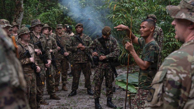 Suriname Armed Forces Sgt. First Class Alvaro Ronoreso teaches survival techniques to U.S. Soldiers and Airmen, as well as Suriname Armed Forces members, during Operation Rumble in the Jungle at Ayoko, Suriname, April 17, 2026. The austere environment survival exchange is designed to test the forces' ability to operate together in demanding jungle conditions, marking 20 years of security cooperation between the South Dakota National Guard and Suriname through the Department of War National Guard Bureau State Partnership Program. Photo by Senior Airman Kyle St. Pierre.