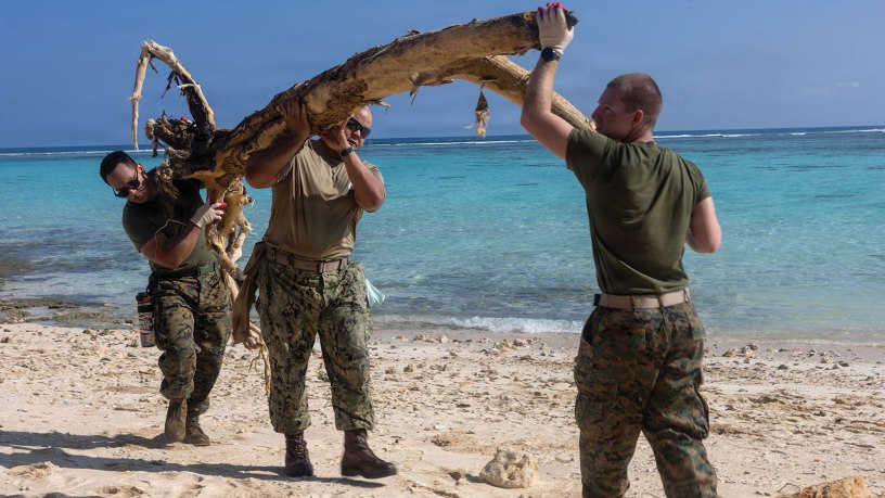 U.S. Sailors and Marines assigned to the Boxer Amphibious Ready Group (ARG) and 11th Marine Expeditionary Unit (MEU), remove debris during a beach cleanup on Ypao Beach, Guam, April 21, 2026.