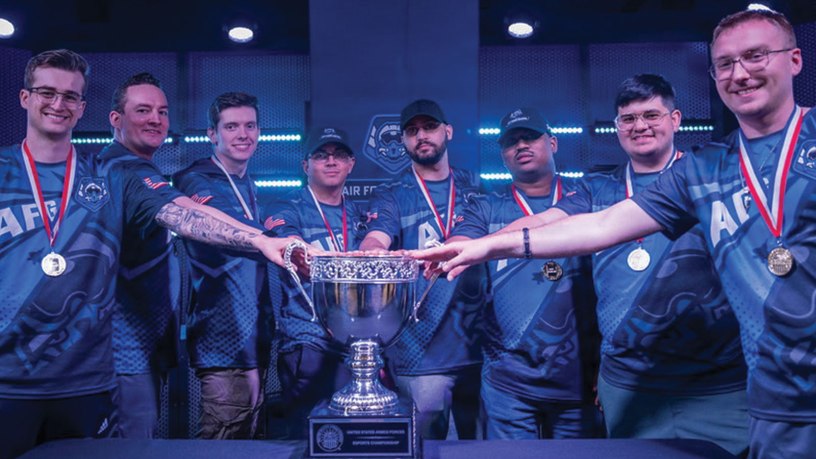 The U.S. Air Force ESports team gather around the tournament trophy after securing victory during the Armed Forces ESports competition April 25, 2026, in Philadelphia. Staff Sgt. Sheldon Cox, 32d Communications Squadron, Iowa Air National Guard, was named MVP of several rounds, leading to a U.S. Air Force victory. (Courtesy Photo)